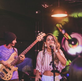 a woman singing into a microphone while holding a guitar