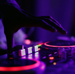 selective focus silhouette photography of man playing red-lighted DJ terminal